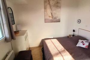 een slaapkamer met een bed en een foto aan de muur bij "LA PERLE MARINE" Appartement, 4 personnes, balcon, vue mer et port de plaisance in Talmont