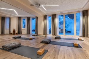 a yoga room with a bunch of pillows and yoga mats at Hotel Alpenhof Superior in Zauchensee