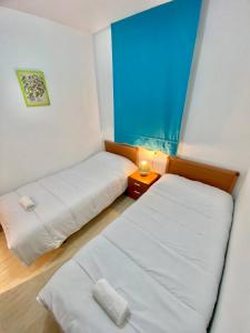 Cette petite chambre comprend deux lits. une table de nuit dans l'établissement Ref 023 Caribbean Coast Apartment I R 023, à El Borseral