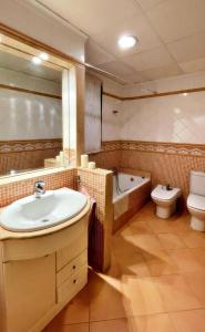 La salle de bains est pourvue d'un lavabo, d'une baignoire et de toilettes. dans l'établissement Apartamento en Torreblanca Ref 061, à Torreblanca