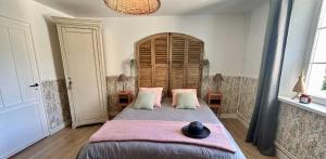 1 dormitorio con 1 cama grande con almohadas rosas en Gîte de la Coursevière - Proximité des plages de la Côte d Opale, Nausicaá et Montreuil-Sur-Mer en Doudeauville