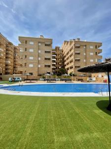 a large swimming pool in front of two large buildings at Apartment Costa Azahar II Ref 012 in El Borseral