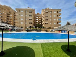 a large swimming pool with two tall buildings at Apartment Costa Azahar II Ref 012 in El Borseral