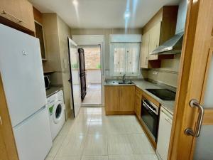 a kitchen with a refrigerator and a sink and a stove at Apartment Costa Azahar II Ref 012 in El Borseral