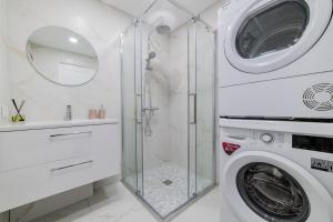 een witte badkamer met een wasmachine en een wastafel bij A.P. Yellow Apartment in Šiauliai