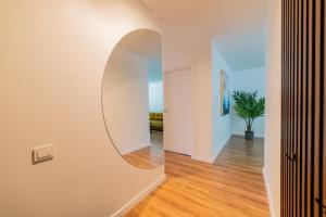 a hallway with a round mirror on the wall at A.P. Yellow Apartment in Šiauliai