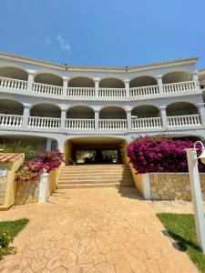 a building with stairs and flowers in front of it at Apartamento Vacacional Vela Blanca Moncofa Ref 055 in Peniscola