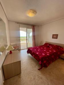 a bedroom with a bed with a red bedspread at Apartamento Vacacional Vela Blanca Moncofa Ref 055 in Peniscola