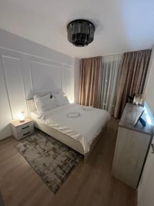 a bedroom with a white bed and a chandelier at Modern Apartment in Timisoara in Timişoara