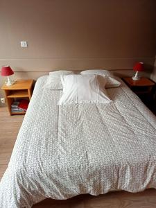 Résidence LE BEC DE L'AIGLE في لو ليوران: غرفة نوم مع سرير مع لحاف أبيض
