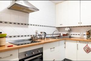 kuchnia z białymi szafkami i zlewem w obiekcie Acogedora Habitacion en apartamento compartido amplio y céntrico w Grenadzie