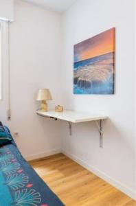 una parete bianca con un tavolo in una stanza di Acogedora Habitacion en apartamento compartido amplio y céntrico a Granada