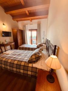 a bedroom with two beds and a table and a lamp at Albergo Diffuso Borgo Retrosi di Amatrice in Amatrice