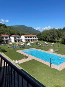 ein großer Pool mit Stühlen und Sonnenschirmen in der Unterkunft Bran Nature&Relax in Costermano sul Garda