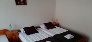 Schlafzimmer mit einem Bett mit weißer Bettwäsche und schwarzen Kissen in der Unterkunft domek jelenia góra in Jelenia Góra