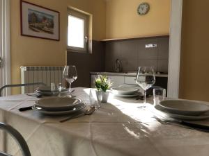 einen Tisch mit Tellern und Weingläsern darauf in der Unterkunft Bran Nature&Relax in Costermano sul Garda