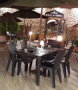 - une table avec des chaises et un parasol dans un restaurant dans l'établissement Hotel The Marins, à Bra