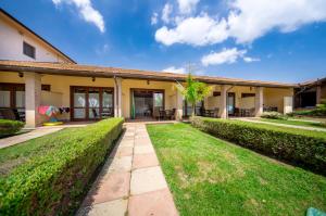 an exterior view of a house with a lawn at Resort Capalbio in Capalbio