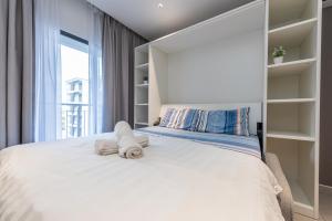 una camera da letto con un grande letto bianco con asciugamani di Balcony studio 2pax near Airport @Dk Impian a Shah Alam