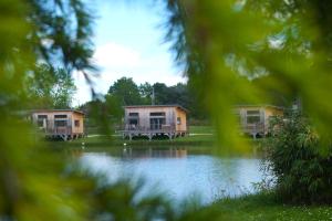 2 cottages situés à côté d'un lac dans l'établissement Écolodges du Golf du Sauternais, à Saint-Loubert