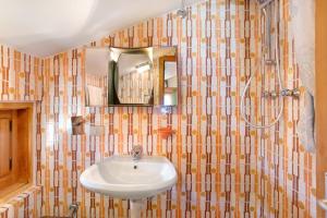 uma casa de banho com um lavatório e um espelho em Appartamento Pablo em Livigno