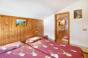 um quarto com 2 camas e uma parede de madeira em Appartamento Pablo em Livigno