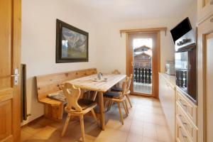 een keuken met een houten tafel en stoelen in een kamer bij Appartamento Pablo in Livigno