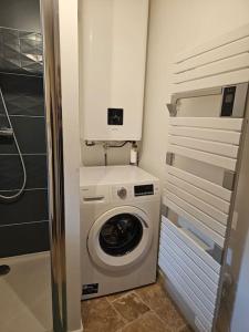 een wasmachine en droger in een kleine badkamer bij Charmante maison troglodyte Loire Valley in Rochecorbon