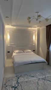 Schlafzimmer mit einem weißen Bett und einer Decke in der Unterkunft Br group in Schymkent