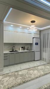 eine Küche mit weißen Schränken und einem Kühlschrank in der Unterkunft Br group in Schymkent