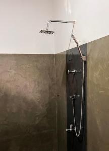 a shower with a shower head in a bathroom at Seek the Sun in Matara