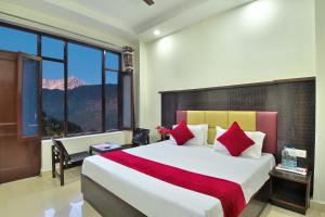 a bedroom with a large bed and a large window at Hotel Nature View near Mall Road in Dharamshala