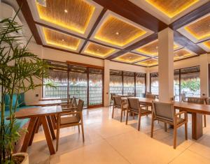 a restaurant with tables and chairs and windows at IZE Canggu by LifestyleRetreats in Canggu