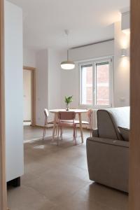 uma sala de estar com uma mesa e um sofá em New Exclusive Melegnano Apartments- Near train station em Melegnano