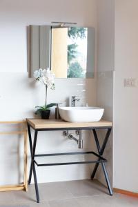 uma casa de banho com um lavatório e um espelho em New Exclusive Melegnano Apartments- Near train station em Melegnano