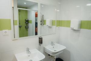a white bathroom with two sinks and a mirror at Onefam Ramblas in Barcelona