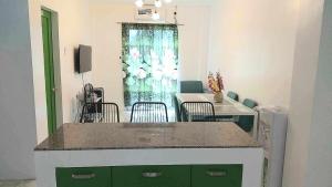 ein Zimmer mit einer Küche mit Tisch und Stühlen in der Unterkunft DeiHouse in Samal