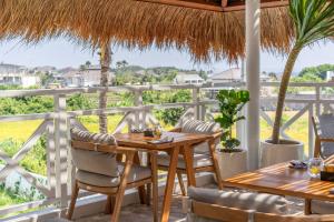 a dining room with a table and chairs on a balcony at IZE Canggu by LifestyleRetreats in Canggu
