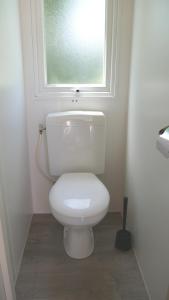 een wit toilet in een badkamer met een raam bij Happy Camp mobile homes in Camping La Vecchia Torre in Gallipoli