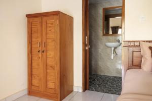 a bathroom with a wooden door and a sink at TwoSpaces Living at Balian Green Lagoon in Balian +69 photos