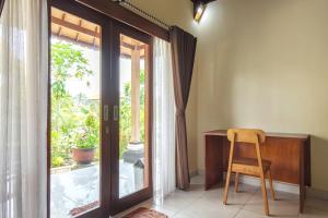 a chair in a room with a desk and a window at TwoSpaces Living at Balian Green Lagoon in Balian