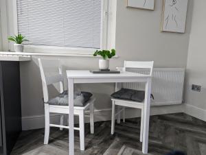 une table et des chaises blanches avec une table et une fenêtre dans l'établissement Wellington Circus, à Nottingham