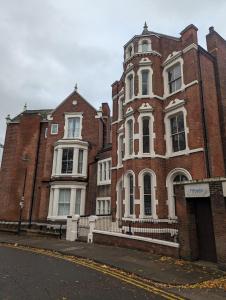 un grand bâtiment en briques rouges sur le côté d'une rue dans l'établissement Wellington Circus, à Nottingham