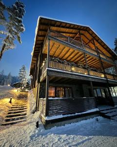 a log cabin in the snow with stairs at Grand Hideout Levi in Kittilä