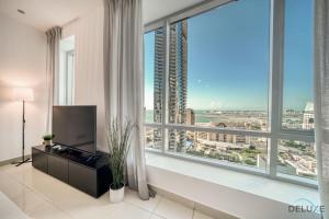 een woonkamer met een groot raam en een televisie bij Gorgeous 1BR at Park Island Blakely Dubai Marina by Deluxe Holiday Homes in Dubai