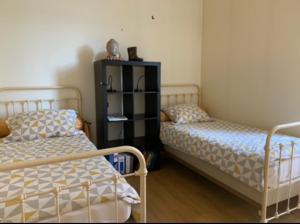 2 nebeneinander sitzende Betten in einem Schlafzimmer in der Unterkunft Chambre privée 2 personnes in Bourganeuf