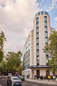 a tall building with cars parked in front of it at ME London by Melia in London