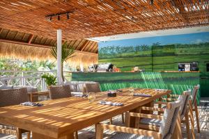 a wooden table and chairs in a restaurant at IZE Canggu by LifestyleRetreats in Canggu