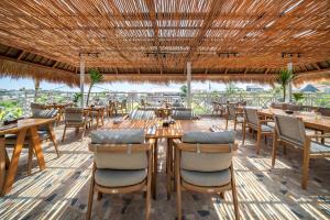 a restaurant with wooden tables and chairs at IZE Canggu by LifestyleRetreats in Canggu