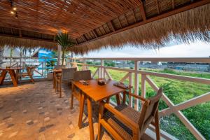 a dining room with a table and chairs on a balcony at IZE Canggu by LifestyleRetreats in Canggu